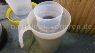 Plastikbecher in Beton